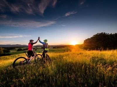 Para na rowerach o zachodzie słońca na Winnym Szlaku Moraw - visitczechia.com